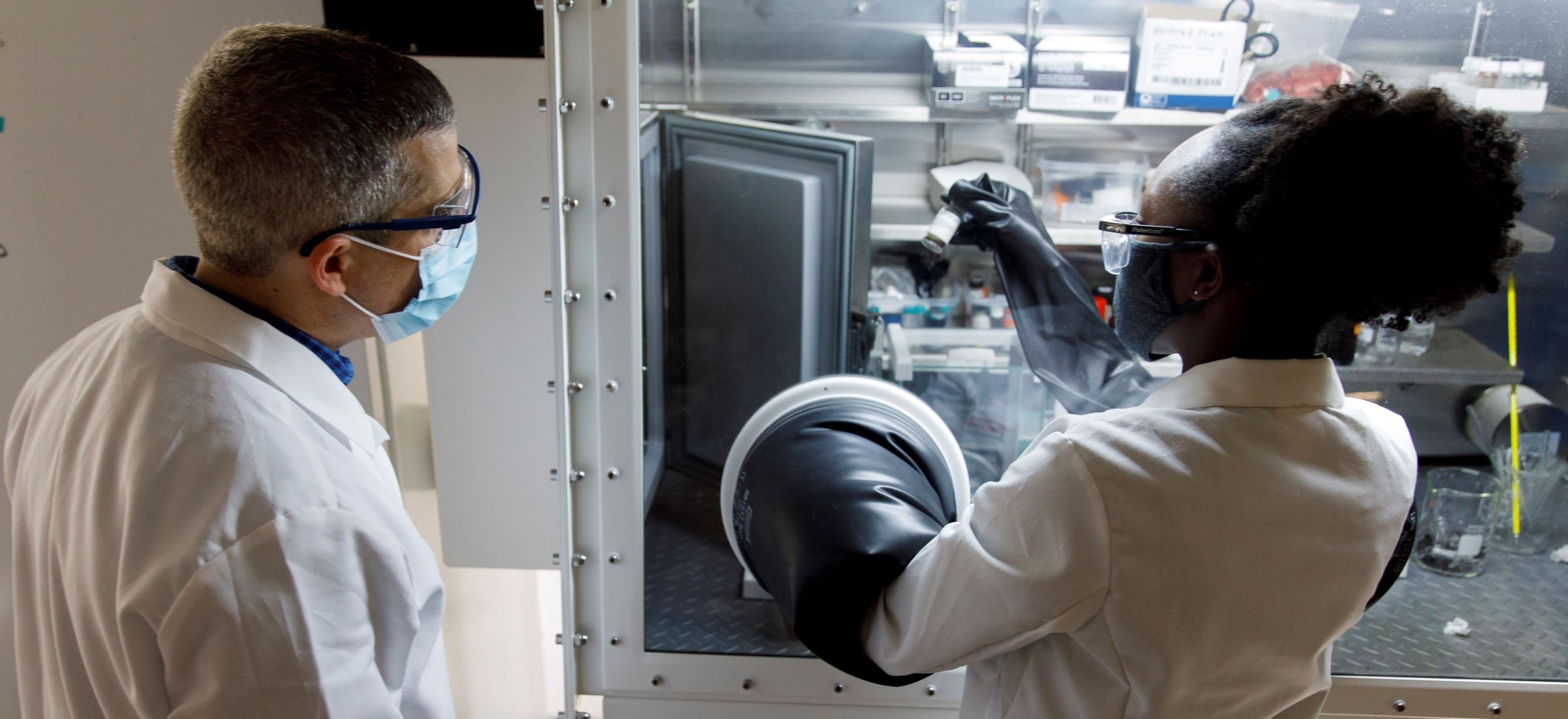 Professor and student working on experiment under fume hood