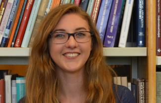 Sarah Elliott stands before a bookcase