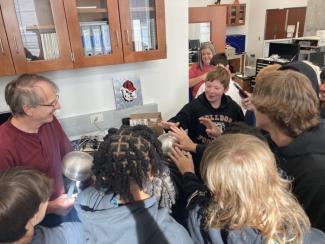 Dr. Dennis Phillips performs a hands-on chemistry demonstration for Oglethorpe Middle School students