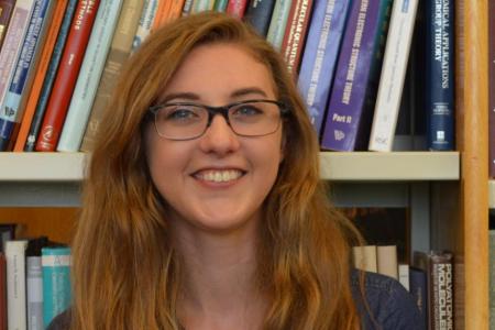 Sarah Elliott stands before a bookcase