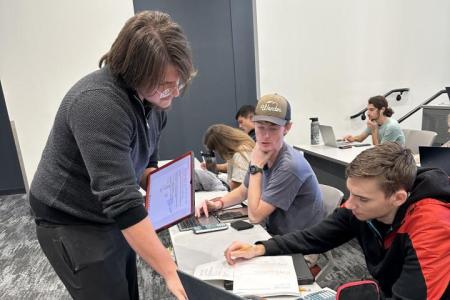 Chemistry Learning Assistant (CLA) working with students in a classroom