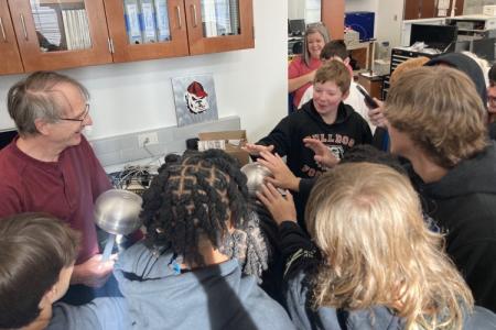 Dr. Dennis Phillips performs a hands-on chemistry demonstration for Oglethorpe Middle School students
