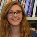 Sarah Elliott stands before a bookcase