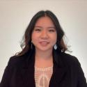 Head shot of Ngan H Thai, Asian woman with long dark hair, wearing a black jacket and lace blouse